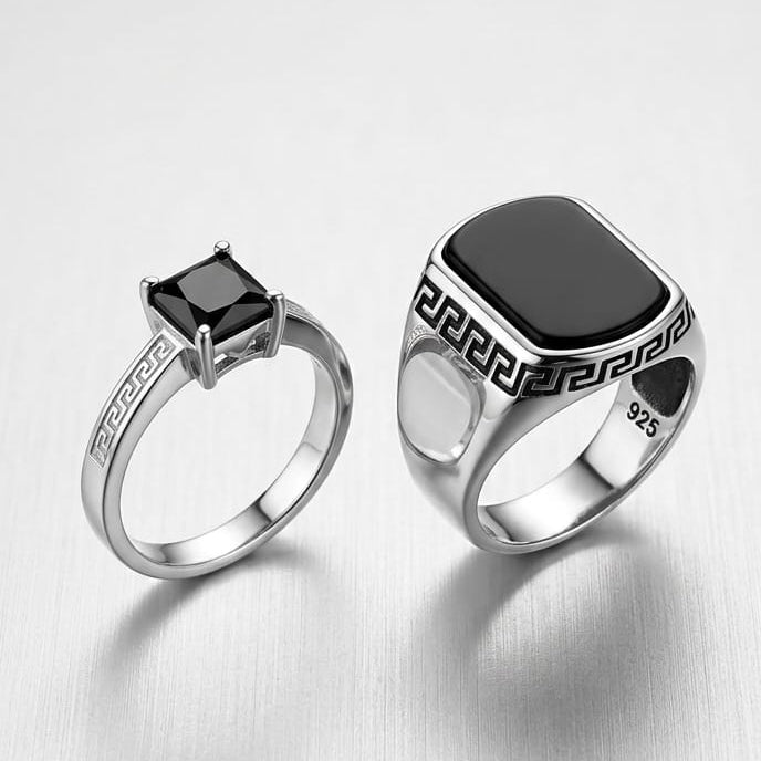 Two silver rings with black stones on a light gray background