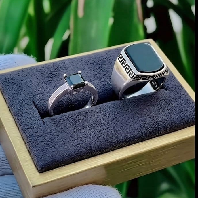 Two rings in a wooden box with a green leafy background
