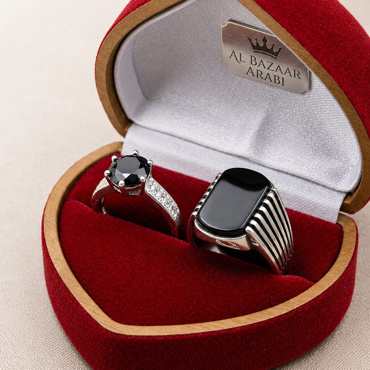 Two rings in a red jewelry box with 'Al Bazaar Arabi' branding.